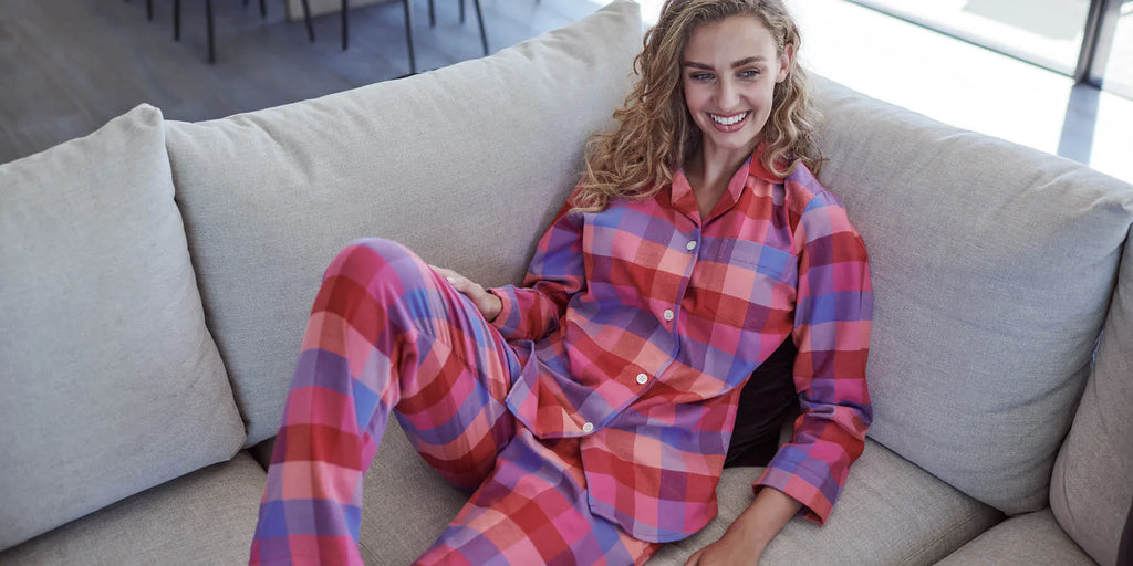 Model lounging whilst wearing British Boxers cotton pyjamas.