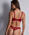 Model wearing 'Danse des Sens' Half Cup Bra in Irresistible Red, by Aubade.