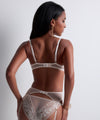 Model wearing 'Flawless Love' Pinkish Beige Mini-Coeur Brief, by Aubade (back view).