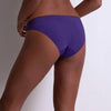 Model wearing 'Illusion Fauve' Brazilian Brief in violet, by Aubade (side view).
