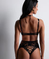 Model wearing 'Night at Paradise' Black Tanga, by Aubade (back view).