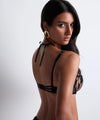 Model wearing 'Night at Paradise' Black Half Cup Bra, by (side view).