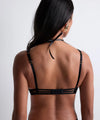 Model wearing 'Night at Paradise' Black Push-Up Plunge Bra, by Aubade (back view).