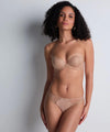 Model wearing 'Sheer Emotion' Sand Moulded Strapless Bra, by Aubade (front view).