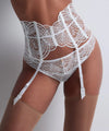 Model wearing 'Vibes' White Tanga, by Aubade (front view, with suspender belt).