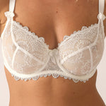 Model wearing 'Louise' Cream Low-neck Bra, by Empreinte (detail).