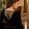 Model wearing 'Deesse en Glam' Long-Sleeved Top in black and gold by Lise Charmel (rear view).