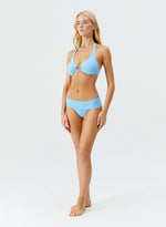 Model wearing 'Brussels' Pale Blue Halterneck Bikini Set, by Melissa Odabash (side view).