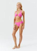 Model wearing 'Brussels' Watermelon Pink Halterneck Bikini Set, by Melissa Odabash (side view).