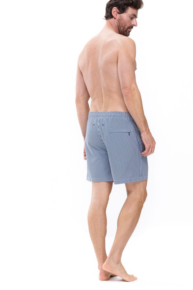 Model wearing 'Beachport' Blue Pinstripe Men's Swimming Shorts, by Mey (back view).