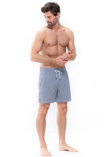 Model wearing 'Beachport' Blue Pinstripe Men's Swimming Shorts, by Mey (front view).