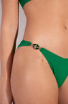 Model wearing 'Chan/Carli' Jade Halterneck Triangle Bikini Set, by Pain de Sucre (front view, focus on jewel on hip).