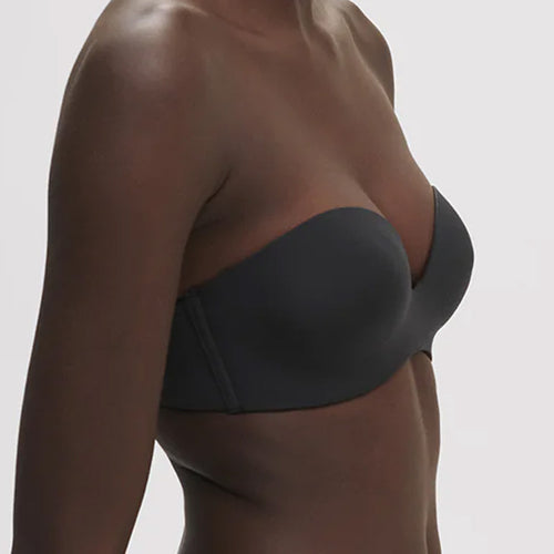 Model wearing 'Essentiel' Black Multi-Position Strapless Bra, by Simone Pérèle (side view, close up).