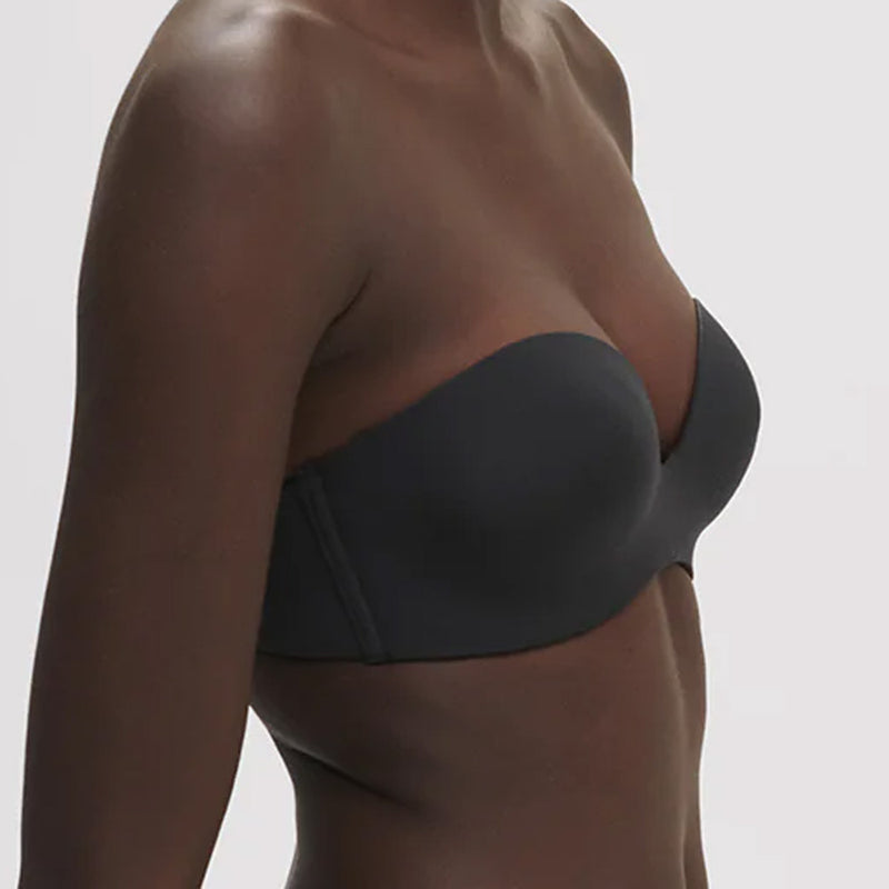 Model wearing 'Essentiel' Black Multi-Position Strapless Bra, by Simone Pérèle (side view, close up).
