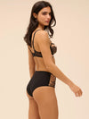 Model wearing 'Romance' Dark Brown Deep Brief, by Simone Pérèle (side view).