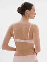 Model wearing 'Saga' Pale Pink Half Cup Bra, from Simone Pérèle (back view).