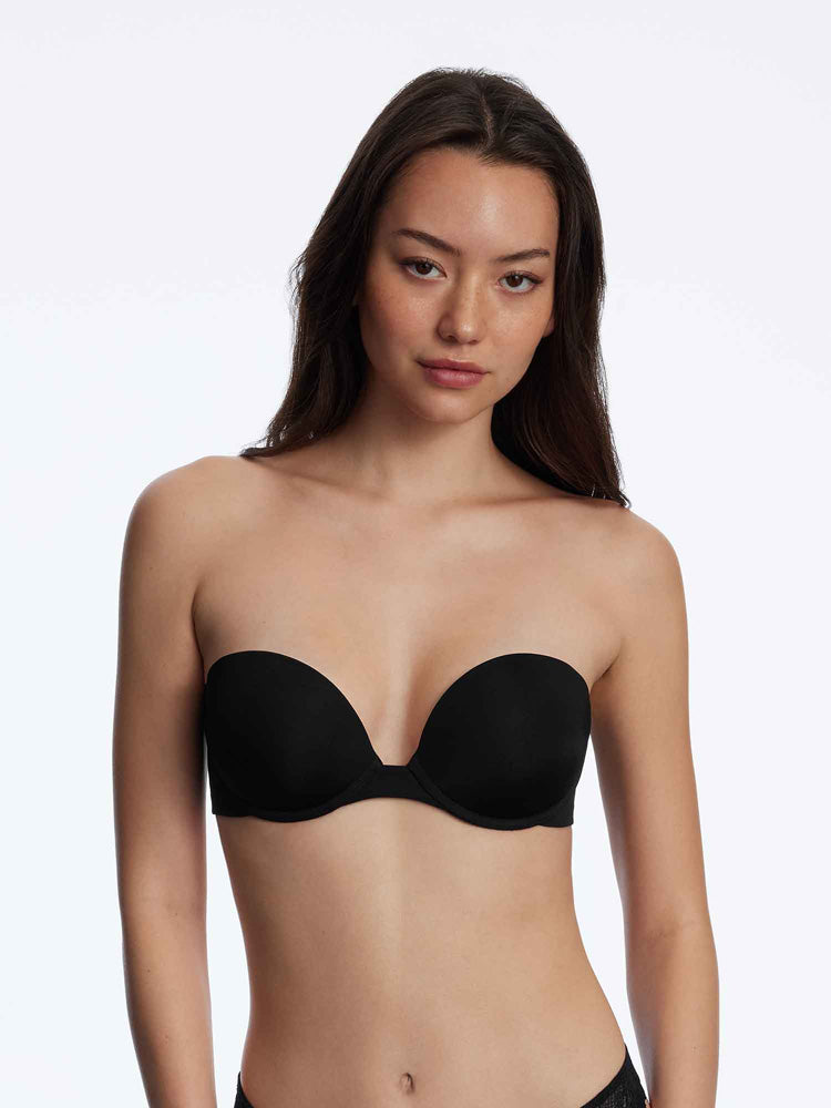 Model wearing 'Breathless' Black Strapless Plunge Push-up Bra, by Skarlett Blue (front view).
