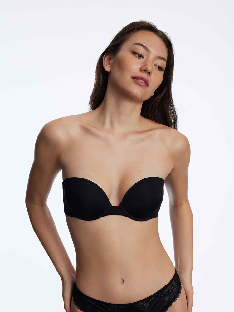 Model wearing 'Breathless' Black Strapless Plunge Push-up Bra, by Skarlett Blue (front view).