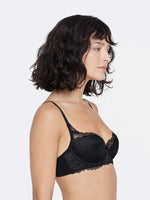 Model wearing 'Minx' Black Padded Balconette Bra, by Skarlett Blue (side view).